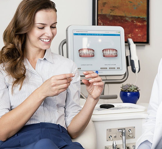 Frau mit Invisalign Zahnschienen vor Ihr vorher-nachher Simulation am itero Scanner