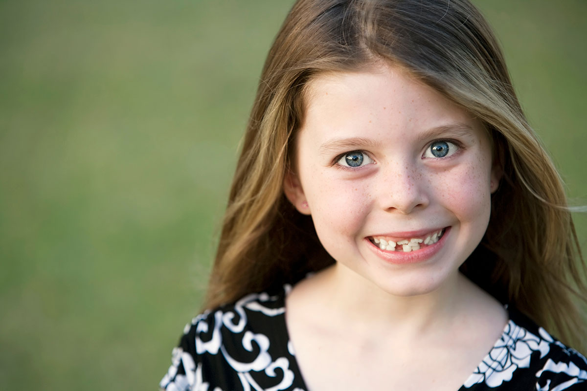 Junge Mädchen lächelt mit schiefe Zähne